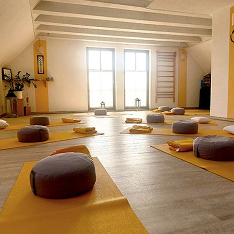 Innenraum-2 Raum mit grauen Sitzkissen und gelben Yogamatten